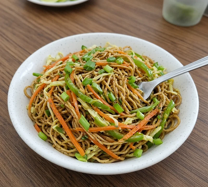 A bowl of veg noodles with a fork